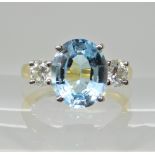 An 18ct gold blue topaz and diamond three stone ring, diamonds estimated approx combined 0.66cts,