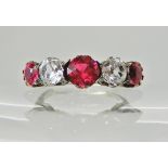 A white metal ring set with red and clear gems, finger size L1/2, weight 3.1gms Condition Report: