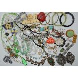 A bag full of vintage costume jewellery to include a small Czech powder compact, a green glass