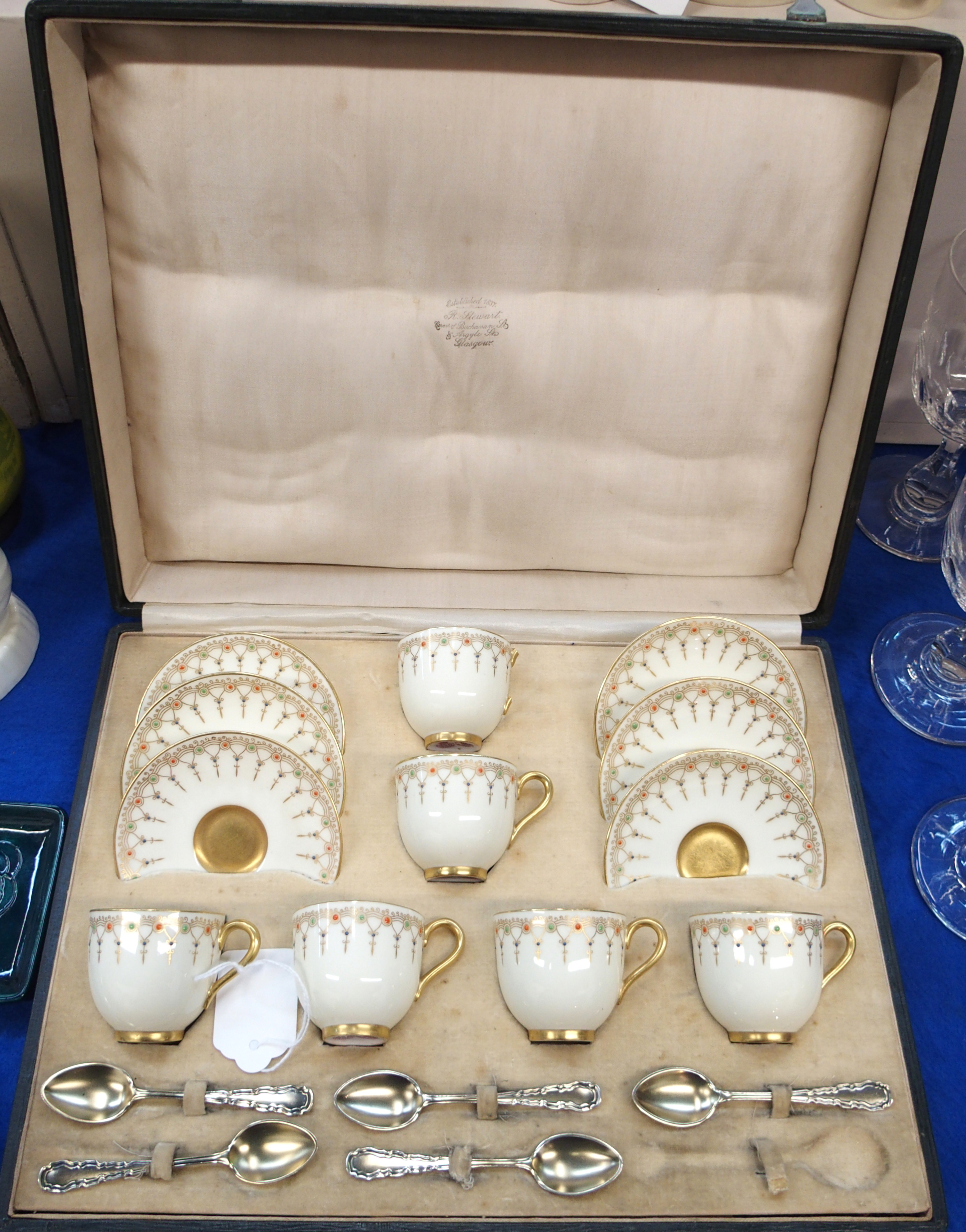 A Royal Worcester demitasse coffee cups and saucers, the cream ground with gilt detail and orange,