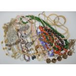 A bag full of vintage costume jewellery to include millefiori beads, two strings of carnelian