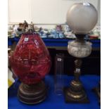 A copper paraffin lamp with large cranberry glass shade, 49cm high overall and another paraffin lamp