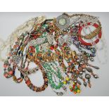 A bag full of vintage costume jewellery to include a glass fruit necklace, Deco necklaces