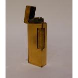 A Dunhill gilt metal cigarette lighter with engine turned body, 6.5cm long Condition Report: