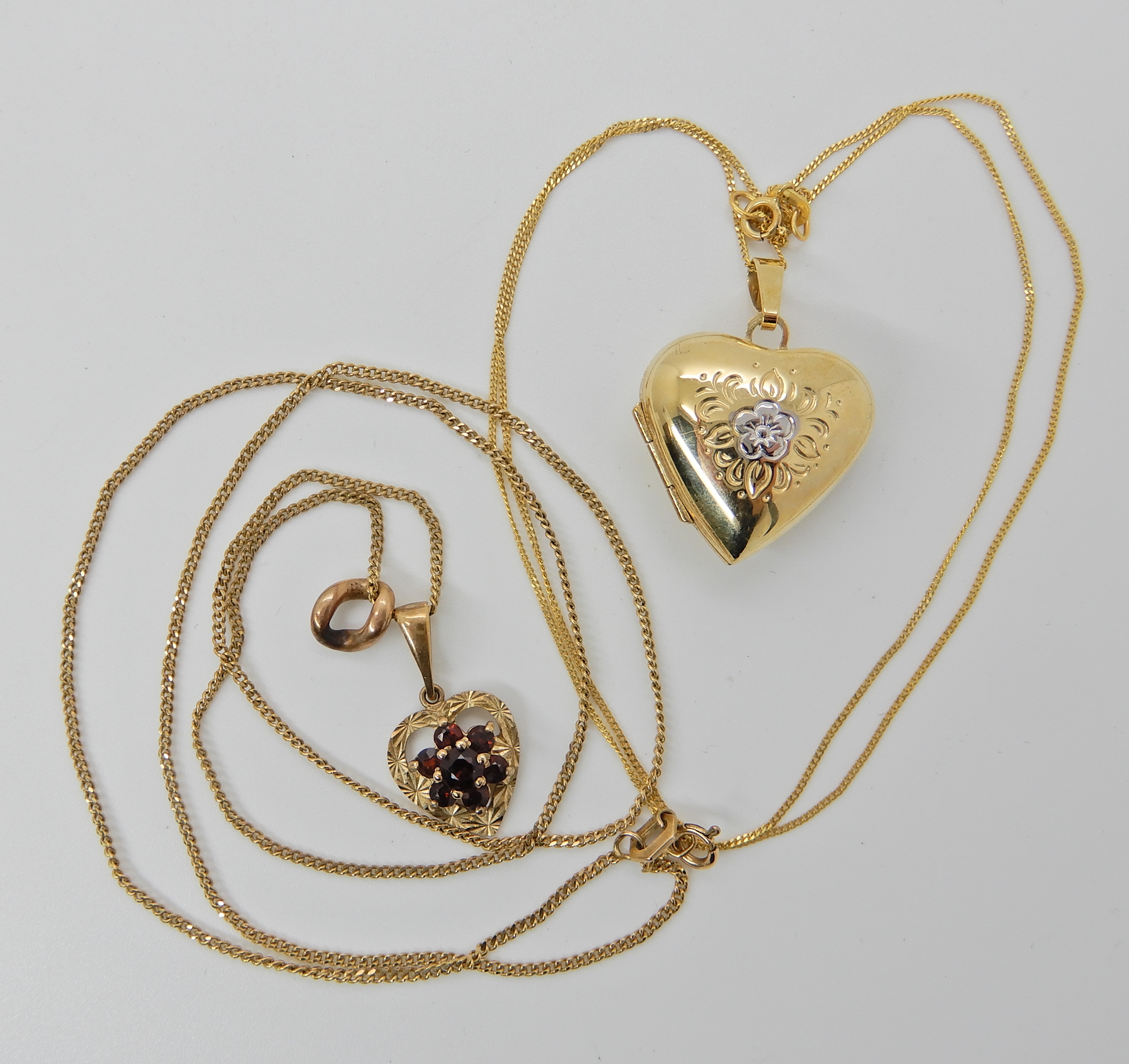 A 9ct gold heart shaped locket 2.8cm x 2cm and chain 45cm long, together with a 9ct gold garnet