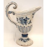 An 18th Century French tin glazed jug with blue and white floral decoration and scrolling handle,