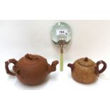Two Chinese yixing teapots, 8cm and 10cm high and a magnifying glass with green hardstone handle,