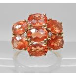 A 9ct gold padparadscha sapphire and diamond accent cluster ring, head size 15.5mm x 18.9mm,