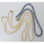 A string of grey pearls with 14k gold clasp, length 40.5cm, a string of white pearls with 18ct