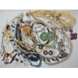 A bag full of vintage costume jewellery to include an Indian enamelled buckle, diamante and other