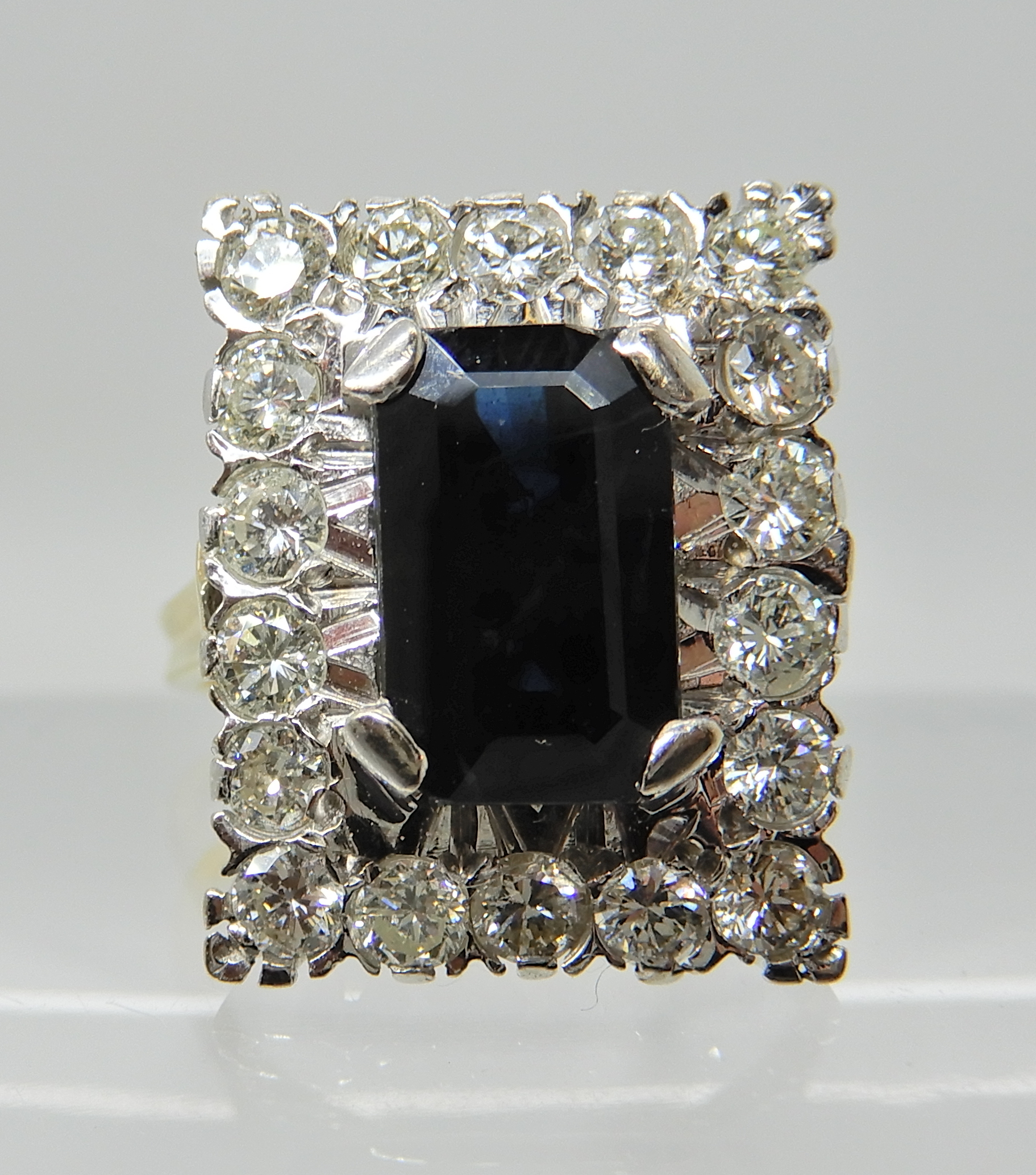 An 18ct gold sapphire and diamond oblong cluster ring, sapphire approx 10.5mm x 6.5cm x 3.7cm,