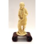 A Japanese ivory figure of a fisherman, on wooden stand, 13.8cm high figure only Condition Report: