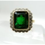An 18ct gold emerald and diamond ring, the central emerald is approx 12mm x 10mm x 5mm and