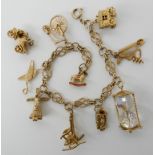 A 9ct gold charm bracelet, with nine attached charms and a loose 9ct old fashioned car charm,