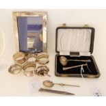 A lot comprising four silver napkin rings, a pair of salts, a spoon and pusher set, anointing