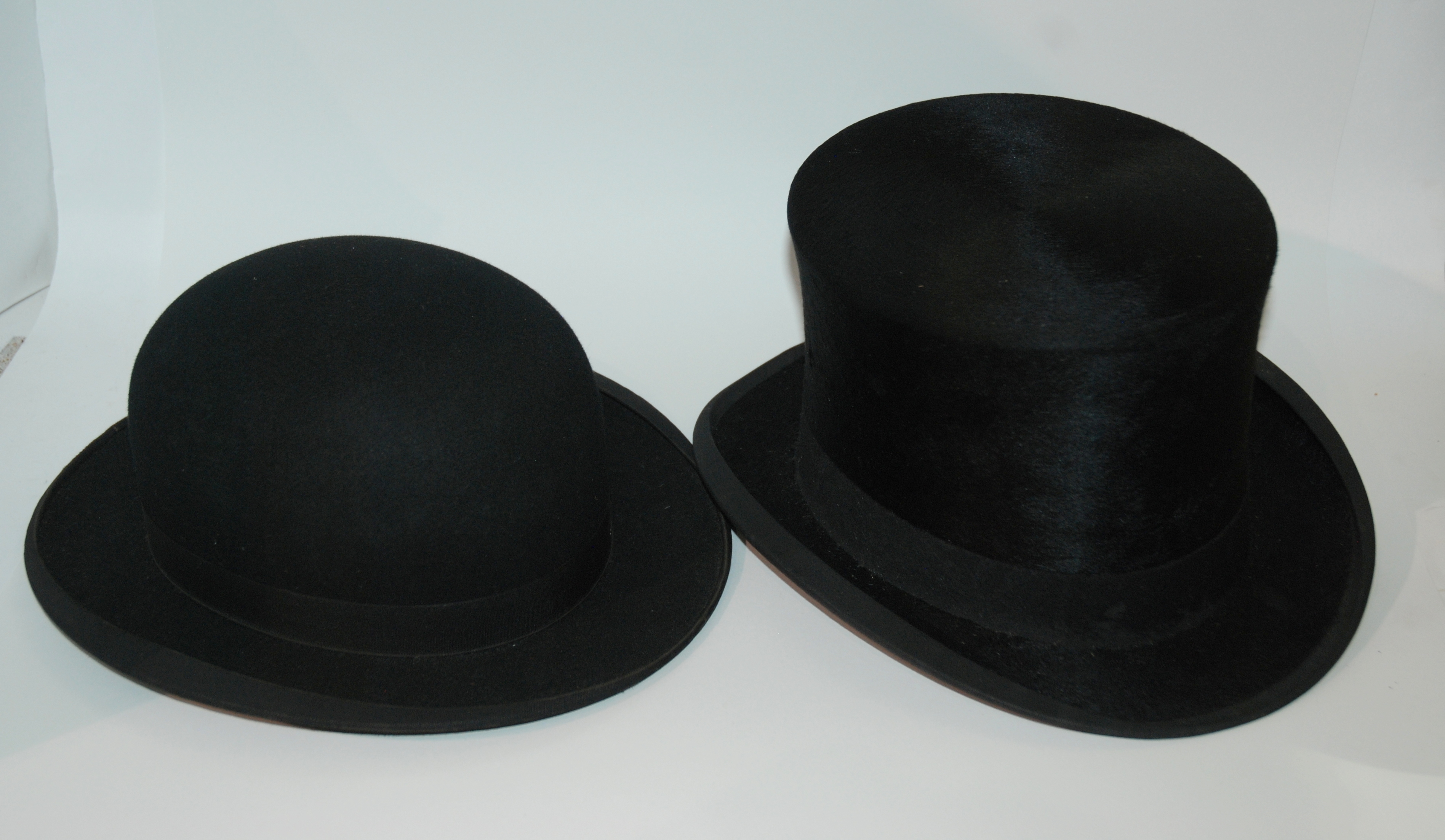 A black top hat and black bowler hat in cardboard cases and white scarf (3) Condition Report: