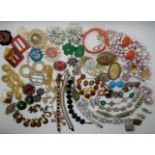 A collection of vintage costume jewellery to include, early coral plastic flower bangle, bracelets
