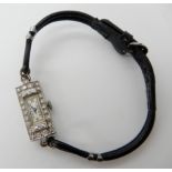 A platinum and diamond cocktail watch, with leather strap. Set with estimated approx 0.60cts of
