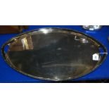 An oval silver plated serving tray with integral twin handles, 62cm across the handles Condition