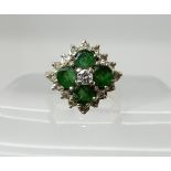 An 18ct gold emerald and diamond cluster ring set with estimated approx 0.20cts of diamonds,