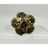 An 18ct gold domed sapphire flower cluster ring, head size approx 19mm (three small sapphires