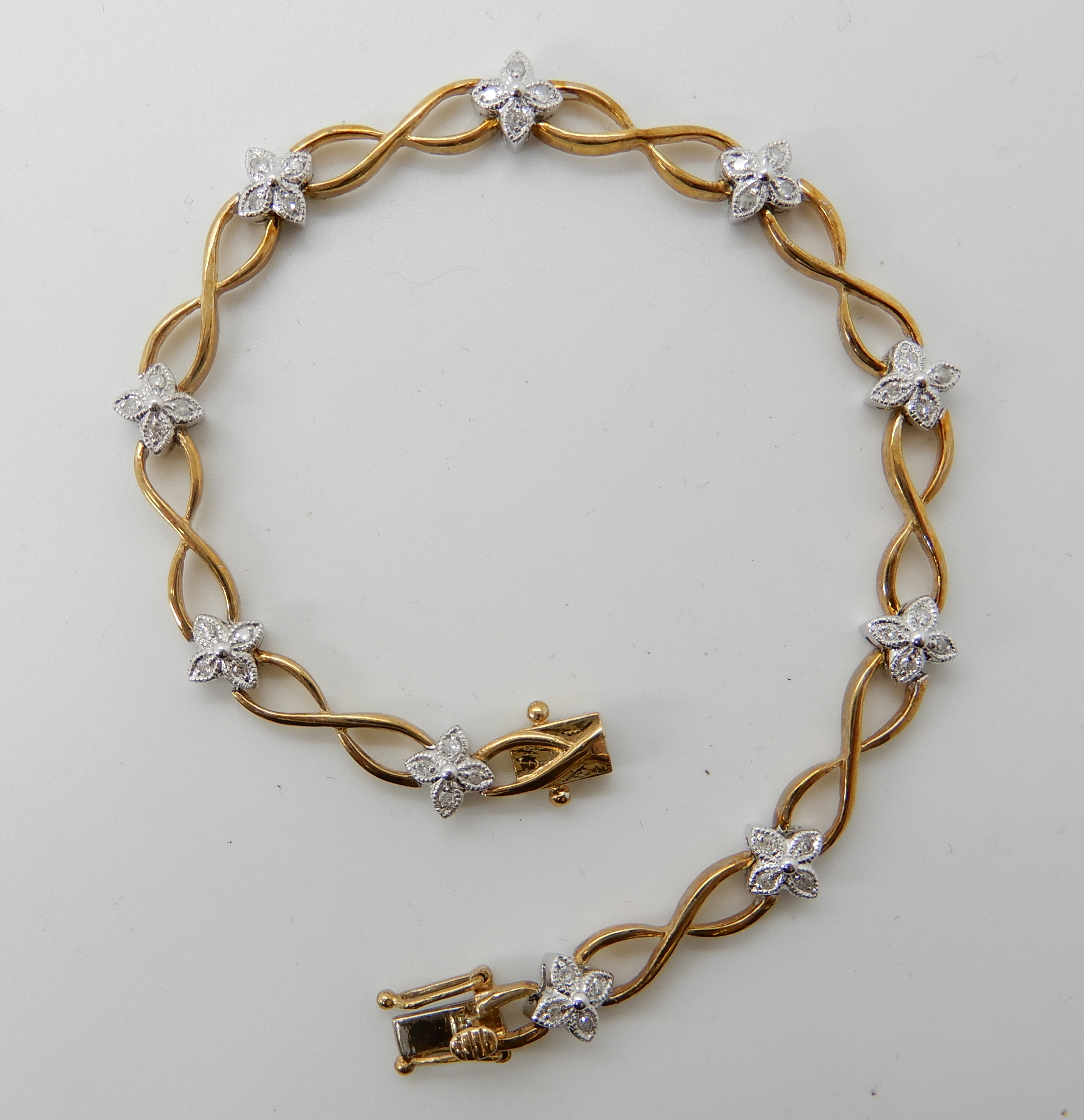 A 9ct gold diamond flower bracelet, set with 0.25cts of eight cut diamonds, length 18cm, weight 8.