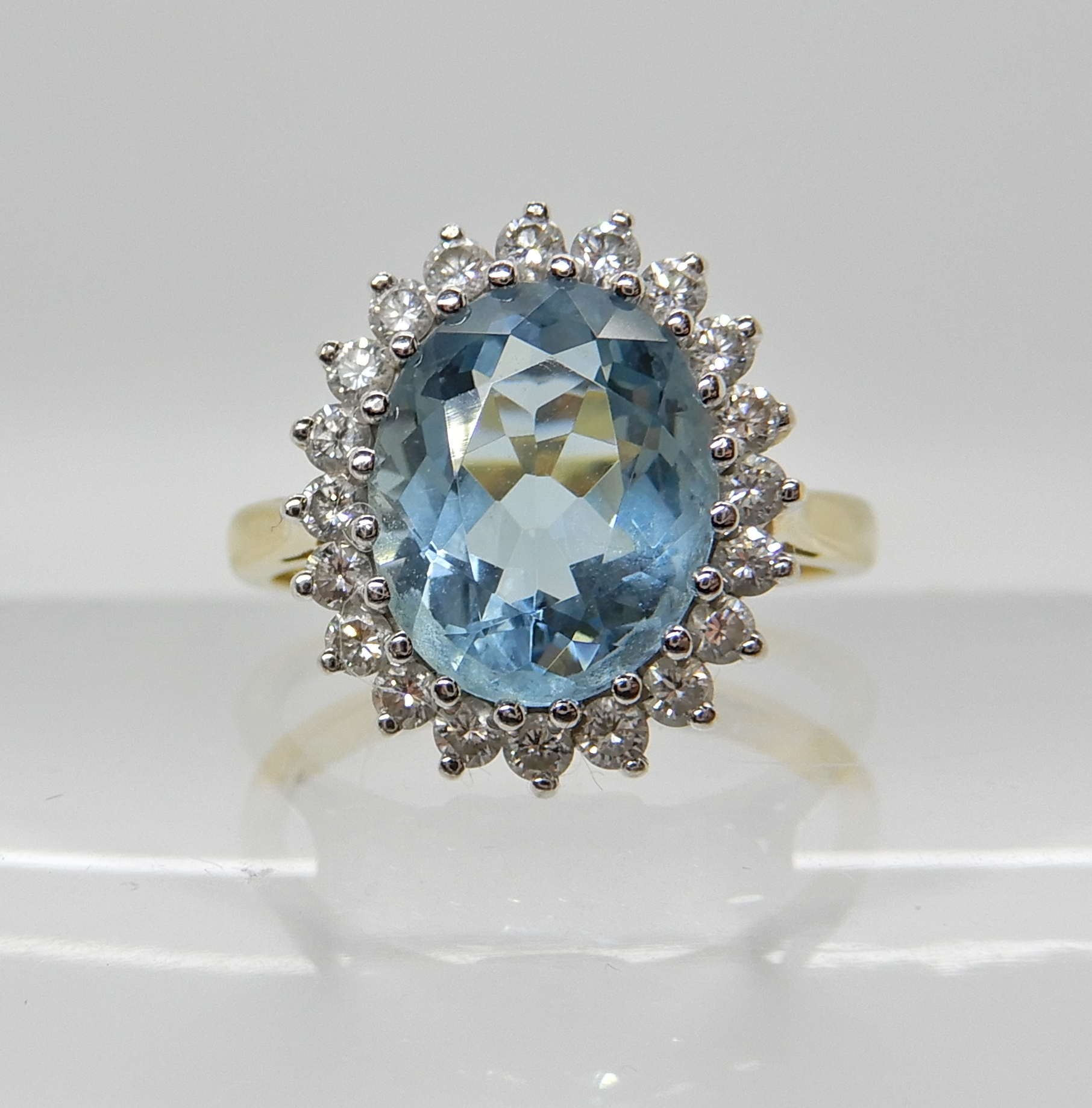 An 18ct gold aquamarine and diamond cluster ring dimensions of the aqua approx 11mm x 9mm x 5.4mm,