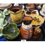 A slip decorated figural jug, 18cm high, a green glazed trefoil owl bowl, a treacle glazed cat