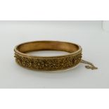 a 9ct gold Etruscan revival bangle, inner diameter 6cm, weight 14.2gms Condition Report: Tongue is