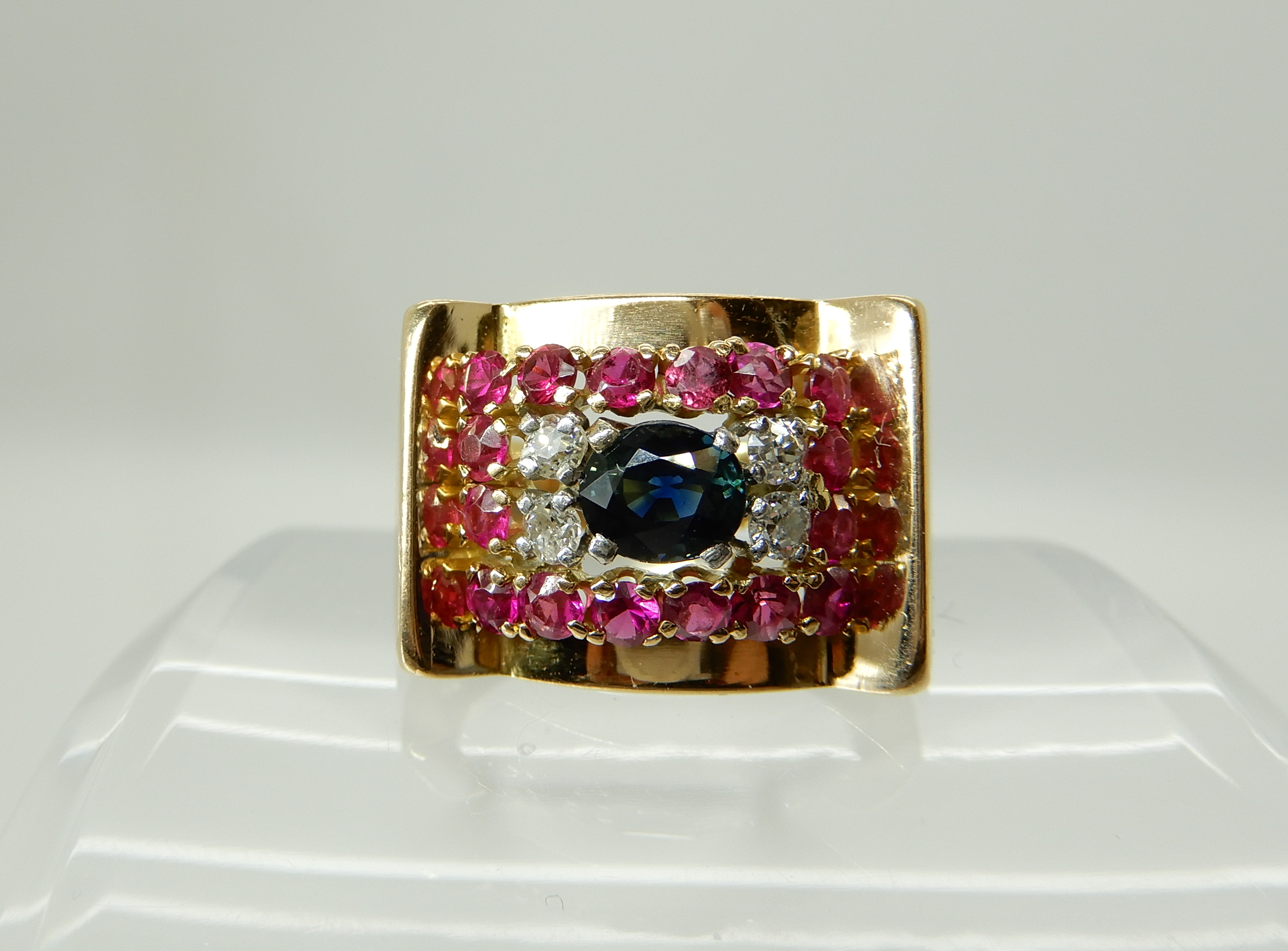 A bright yellow metal sapphire diamonds and red gem set gents ring, size U, weight 10.6gms Condition