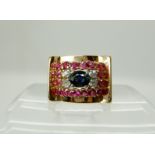 A bright yellow metal sapphire diamonds and red gem set gents ring, size U, weight 10.6gms Condition