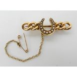 A bright yellow metal chain link brooch with a pearl set horseshoe, length 3.7cm, weight 4.2gms