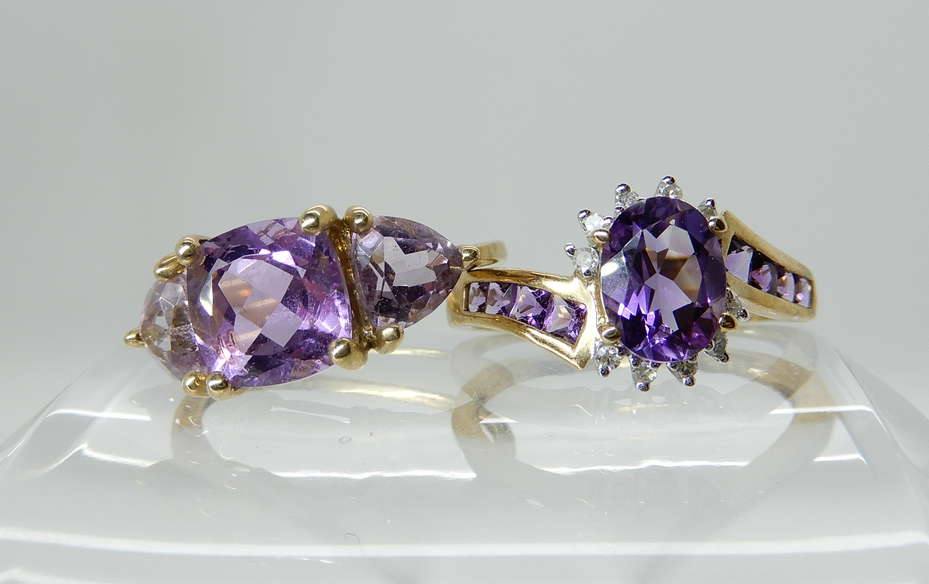 A 9ct gold amethyst and diamond ring, size Q1/2, a 9ct gold three stone amethyst ring size P1/2,