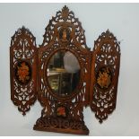 A carved inlaid mirror with hinged flaps and pictorial panels, 40cm high x 35cm open Condition