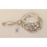 A silver mounted hand mirror by Thomas Bishton, Birmingham 1910, with embossed floral decoration