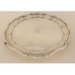 A silver card tray by Mappin & Webb, London 1912, of circular form with scalloped rim on three