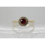 An 18ct gold ruby and diamond cluster ring, head size 7mm, finger size M, weight 2.2gms Condition