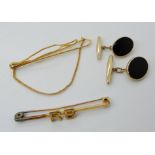 A pair of 9ct onyx set cufflinks, a yellow metal bar brooch and tie clip, weight 12.1gms Condition