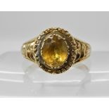 An early Victorian style citrine ring with reeded shoulders and engraving surrounding the foiled