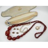 A string of cherry Bakelite beads, faux pearls and other items Condition Report: Not available for