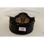 A Royal Navy Officer's cap with label Royal Navy Hat and Cap Company Limited and marked in ink A.G.