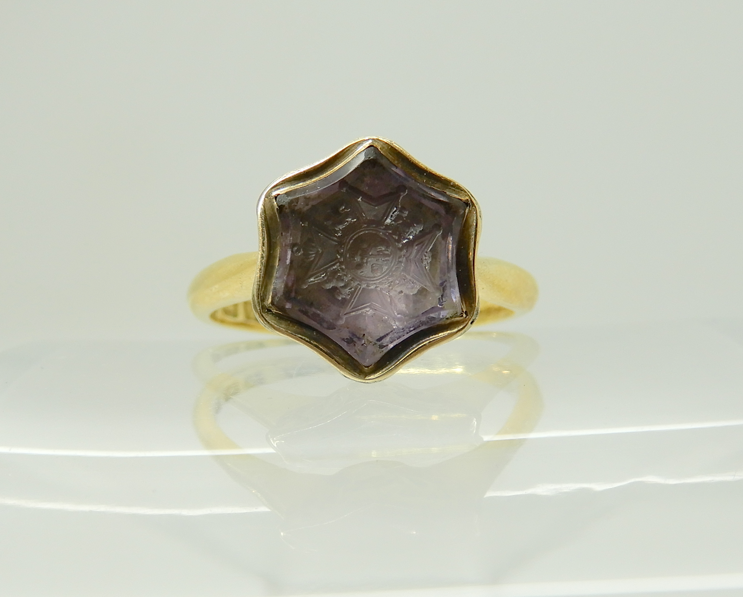 An 18ct gold intaglio engraved amethyst signet ring, carved with a Knights cross, hallmarked