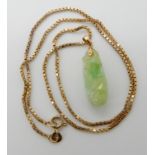 A 14ct gold mounted Chinese green hardstone pendant carved with an aubergine, length 3.2cm with a