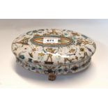 An Italian faience oval pot and cover painted with cherubs, marked Pesaro to base, 22cm long
