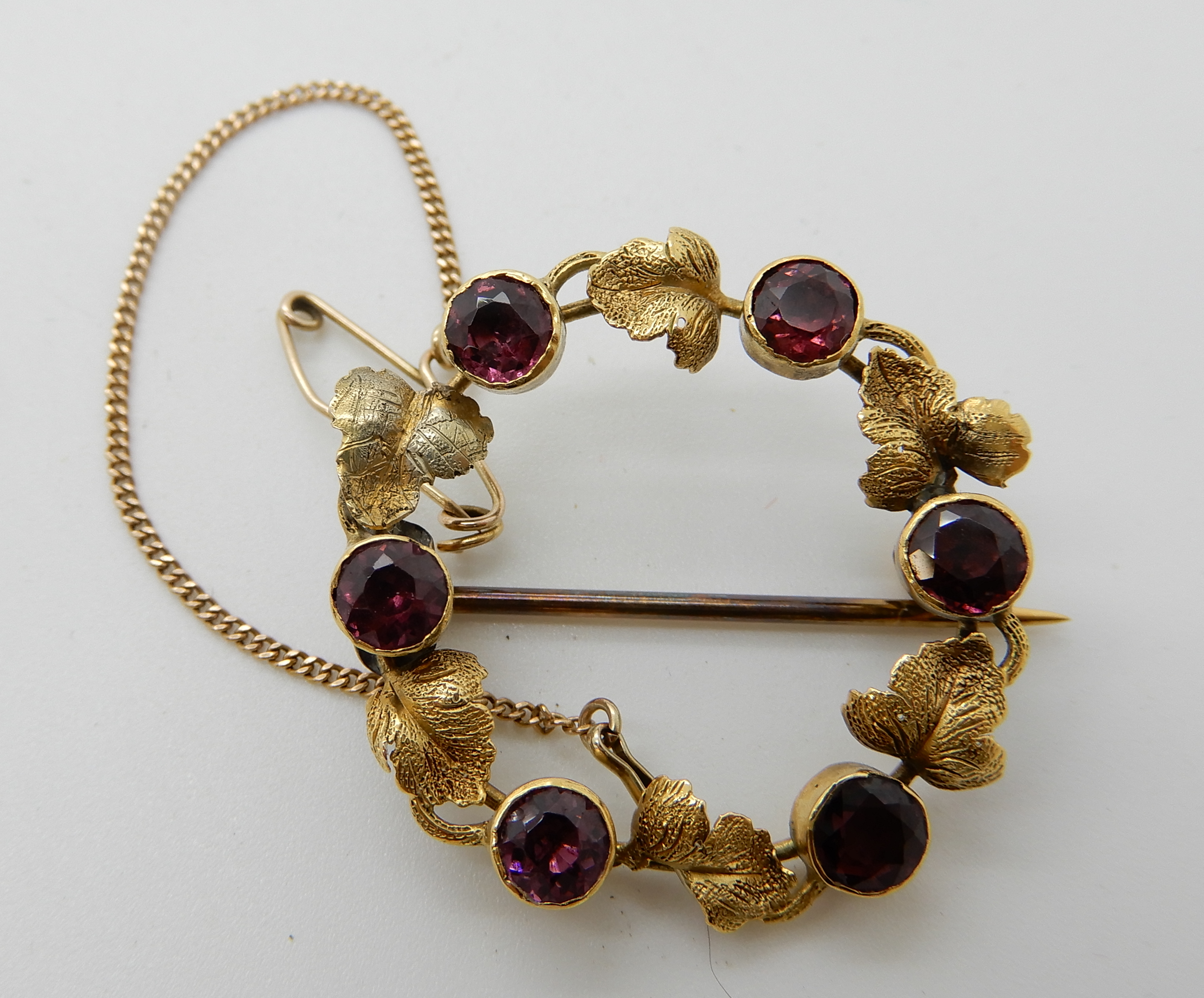 A bright yellow metal leaf brooch set with garnets, weight 3.7gms Condition Report: Available upon