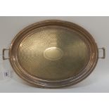 A silver plated twin handled serving tray of oval form with engine turned decoration, 46cm across