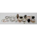 A collection of silver and white metal rings to include a carved onyx face, moss agate, dichroic