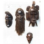 Four African wooden wall masks Condition Report: Available upon request