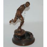 A spelter figure of a footballer with associated ashtray base, 19cm high Condition Report: Available