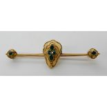 A 15ct gold Etruscan design brooch set with green gems, length 6.1cm, weight 3.6gms Condition